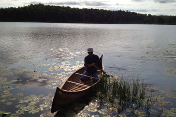 Man paddling a canoe along the river