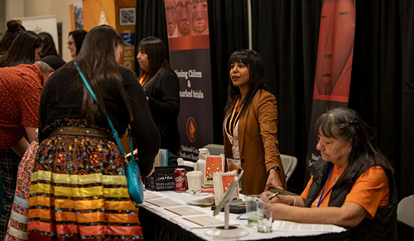 Women speaking over a sponsor table