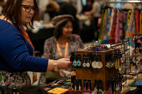 Woman looking at earrings at an Indigenous Artisan Market