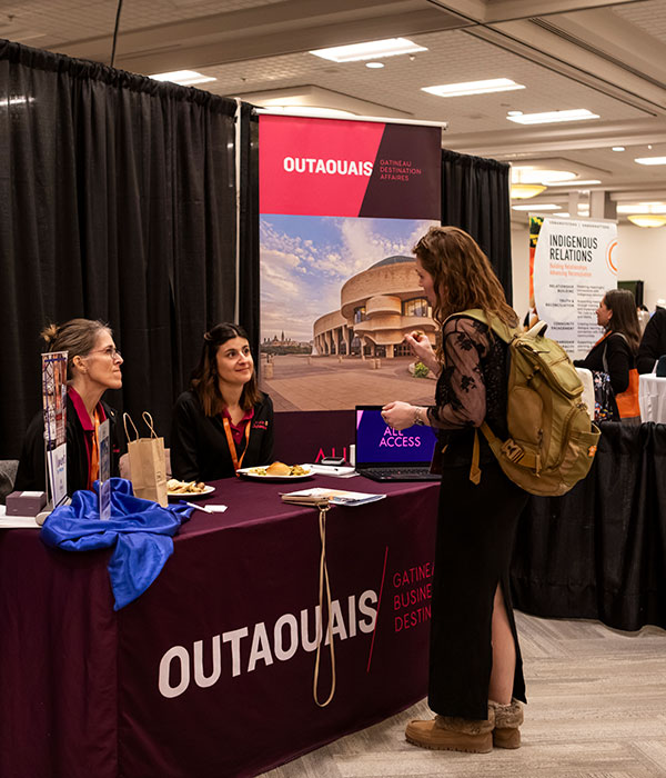 Two women speaking at a Sponsor Table